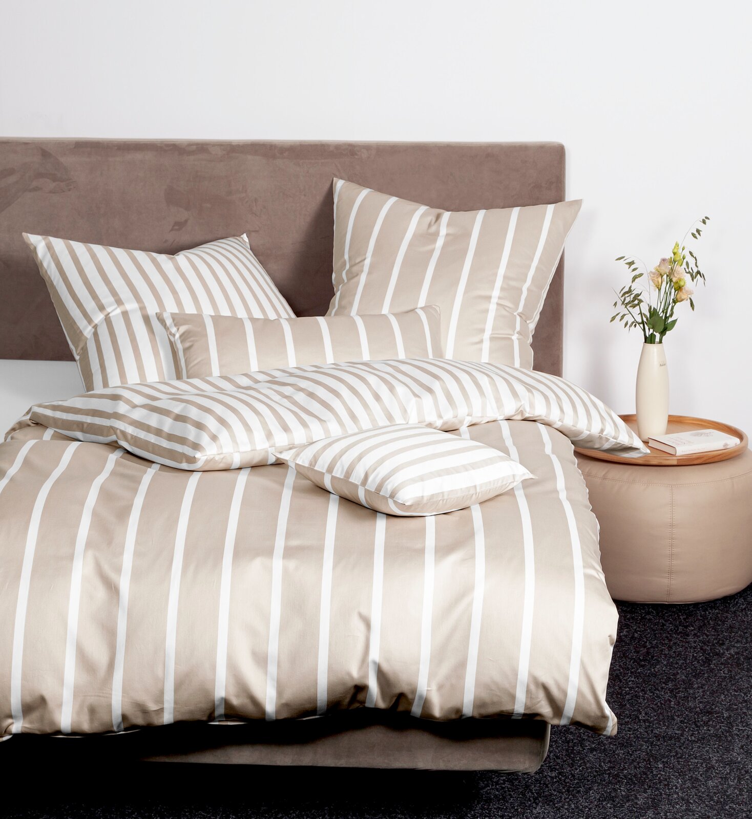 Bettwäsche-Set mit beigen und weißen Streifen auf einem Bett, seitliche Perspektive