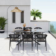 Moderner Stapelsessel auf einer Terrasse mit Meerblick, umgeben von einem stilvollen Esstisch-Set und Pflanzen, aus der Vogelperspektive fotografiert.