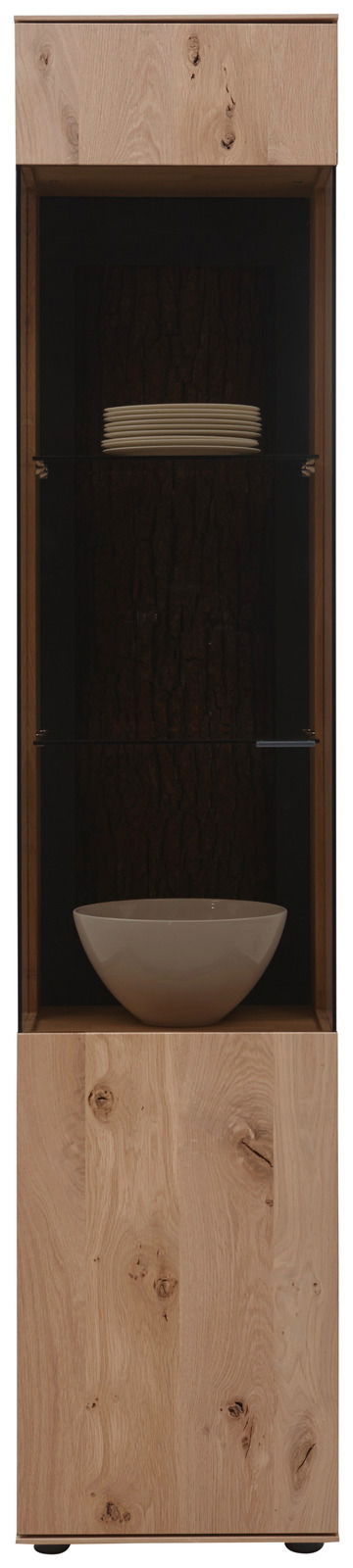 Frontale Ansicht der Valnatura Vitrine LAVIA mit Holzelementen und Glastür, gefüllt mit weißen Tellern und einer Schale.