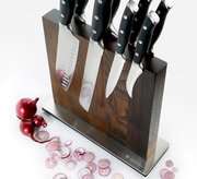 Magnet-Messerblock aus Esche mit mehreren Messern, seitliche Perspektive, umgeben von geschnittenen roten Zwiebeln.