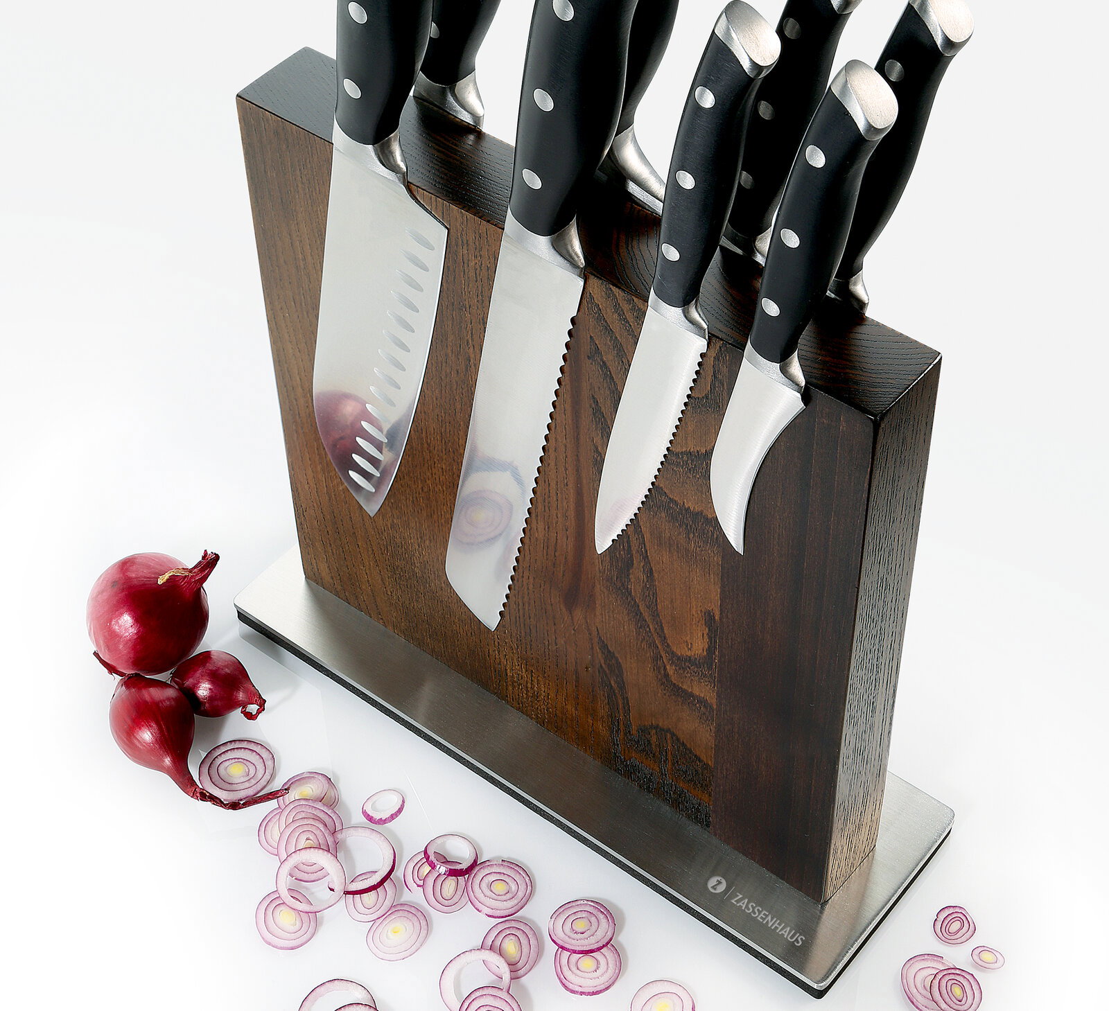 Magnet-Messerblock aus Esche mit mehreren Messern, seitliche Perspektive, umgeben von geschnittenen roten Zwiebeln.