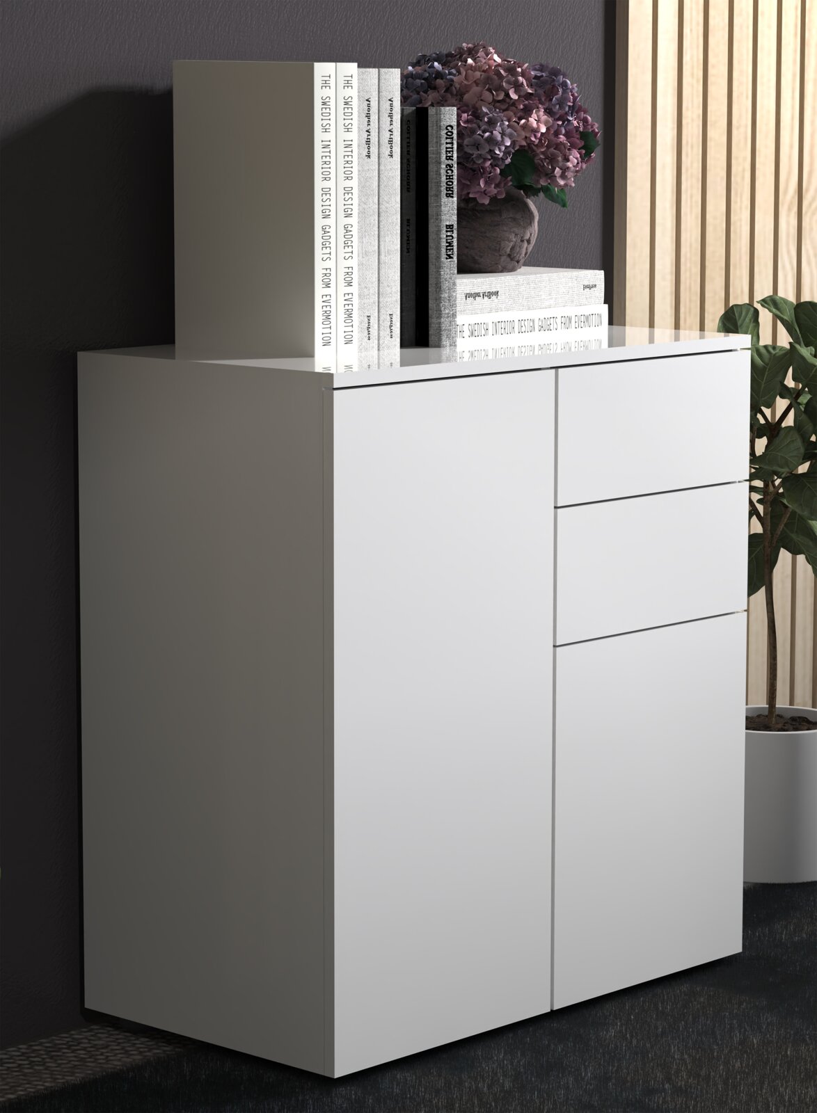 Modernes weißes Sideboard/Kommode mit glatten Fronten und drei Schubladen rechts, links eine Tür; oben dekoriert mit Büchern und Blumentopf, perspektivische Ansicht schräg von vorne links.