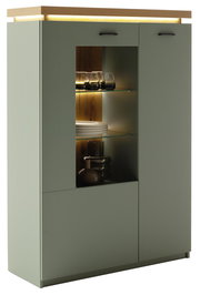 Moderne Vitrine/Highboard in mattem Salbeigrün mit Holz-Deckplatte, Glastür mit Glasböden und warmer LED-Beleuchtung, Frontansicht leicht schräg von links