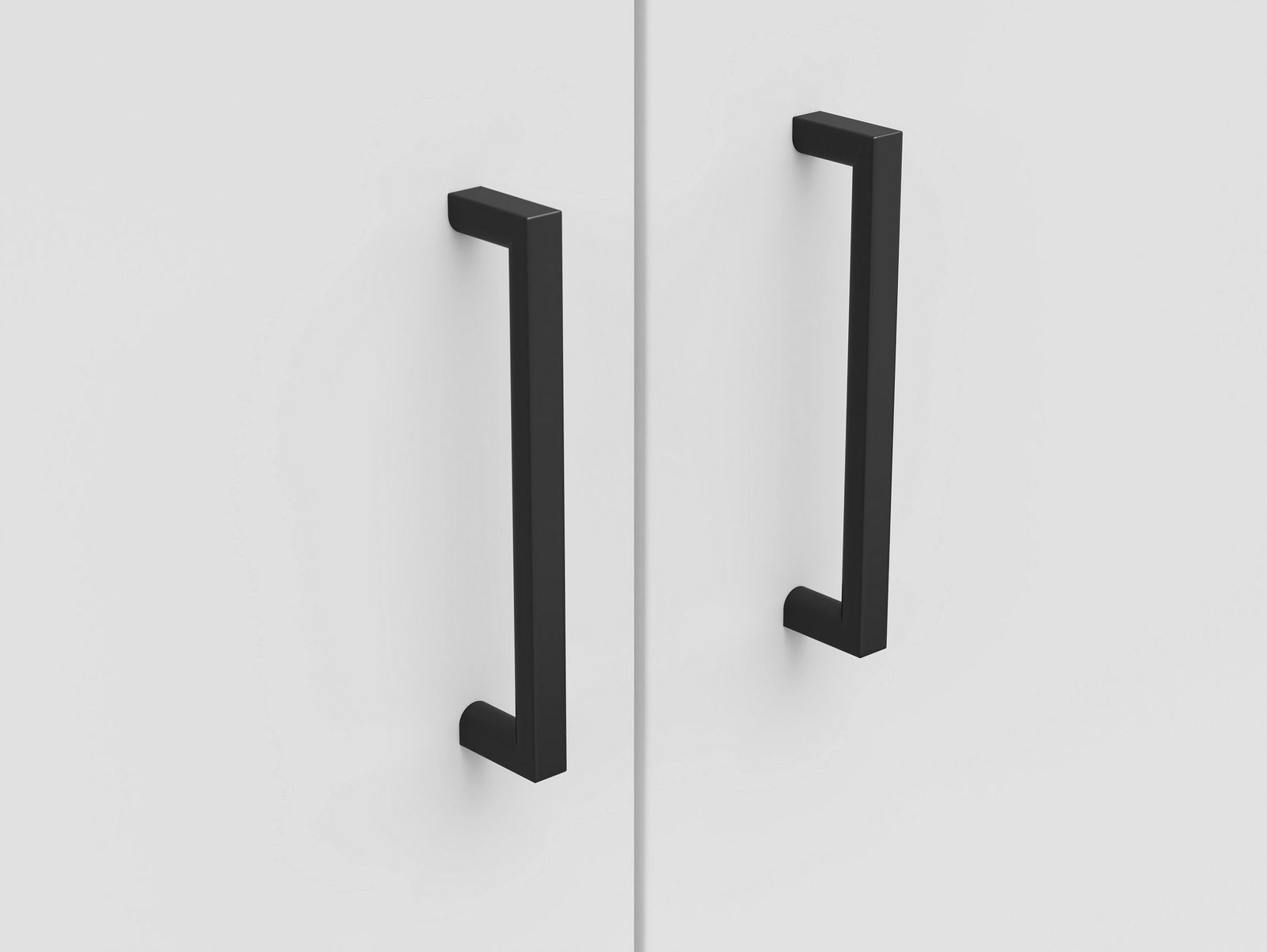 Nahaufnahme von zwei schwarzen Griffen an einer weißen Kommode, frontal betrachtet.