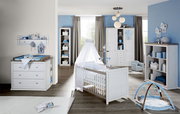 Kinderzimmer mit Wickelkommode, Kinderbett mit Himmel und Regal, seitliche Perspektive