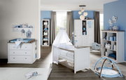 Kinderzimmer mit Wickelkommode, Kinderbett mit Himmel und Regal, seitliche Perspektive