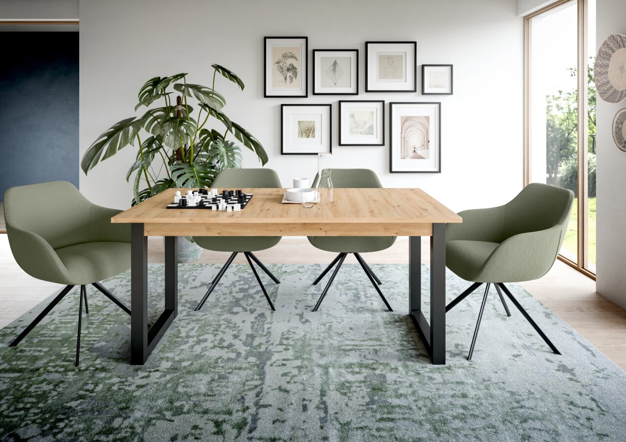 MID.YOU Esstisch SEATTLE Moderner Esstisch mit Holzplatte und schwarzen Metallbeinen, umgeben von vier grünen Stühlen in einem stilvoll eingerichteten Raum mit Pflanzen und Wandbildern, aus frontaler Perspektive.