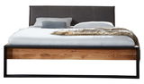 Frontale Ansicht eines modernen Balkenbetts mit Holzrahmen und gepolstertem Kopfteil, dekoriert mit Kissen und einer Decke.