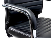 Nahaufnahme eines schwarzen Schwingstuhls mit gepolsterten Armlehnen und verchromtem Gestell, seitliche Perspektive