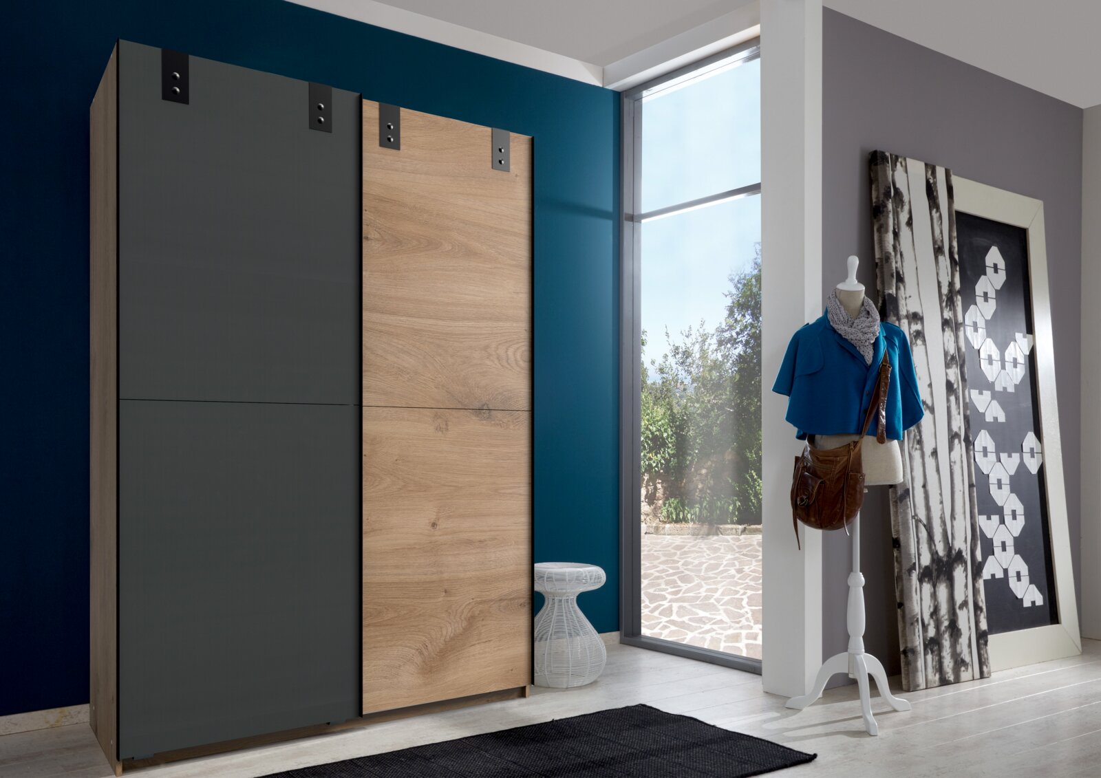Moderner Schwebetürenschrank CARDIFF mit zwei Türen, eine in Holzoptik und die andere in dunklem Grau, in einem stilvollen Raum mit Blick auf den Schrank von vorne.