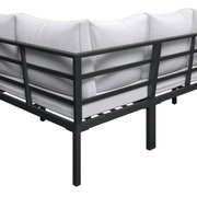 Eckmodul einer Outdoor-Lounge mit schwarzem Metallrahmen und hellgrauen Polstern, Ansicht schräg von hinten/seitlich.