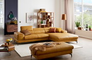 Moderner, senfgelber Hocker in einem stilvoll eingerichteten Wohnzimmer, aus der Vorderansicht fotografiert.