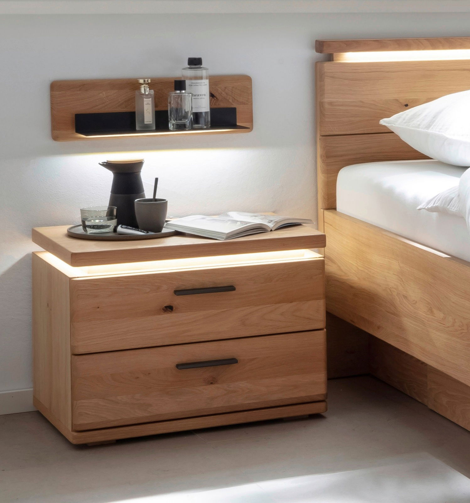 Nachtkonsole aus Holz mit zwei Schubladen, dekoriert mit einer Karaffe, Tasse und einem Buch, seitliche Perspektive