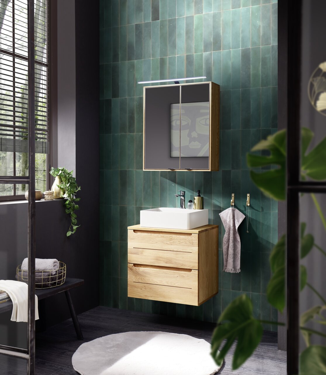 Moderner Spiegelschrank in einem stilvollen Badezimmer mit grünen Fliesen, aus der Perspektive von vorne betrachtet.