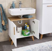 Waschbeckenunterschrank mit offenen Türen, gefüllt mit Reinigungsmitteln und Toilettenpapier, aus einer frontalen Perspektive fotografiert.