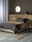 Bett mit gestreifter Bettwäsche in Erdtönen, seitliche Perspektive, modernes Schlafzimmerdesign mit Holzkopfteil und runder Wandspiegel.