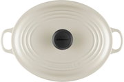 Ovaler Le Creuset Gusseisen-Bräter mit Deckel in Cremeweiß, mit seitlichen Griffen und schwarzem Deckelknopf, Draufsicht von oben