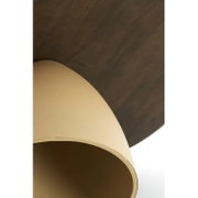 Close-up van een opgerold tapijt in beige met een donkere achterkant, schuin van bovenaf gefotografeerd