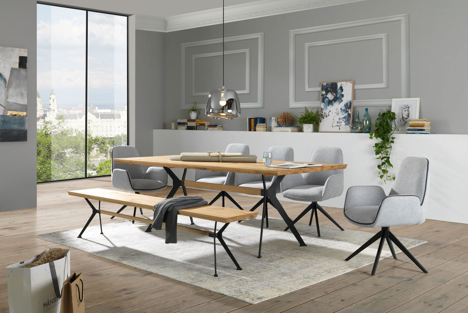 Esszimmer mit modernem Tisch, Sitzbank und Sesseln in einem hellen Raum mit Blick auf die Stadt, seitliche Perspektive.