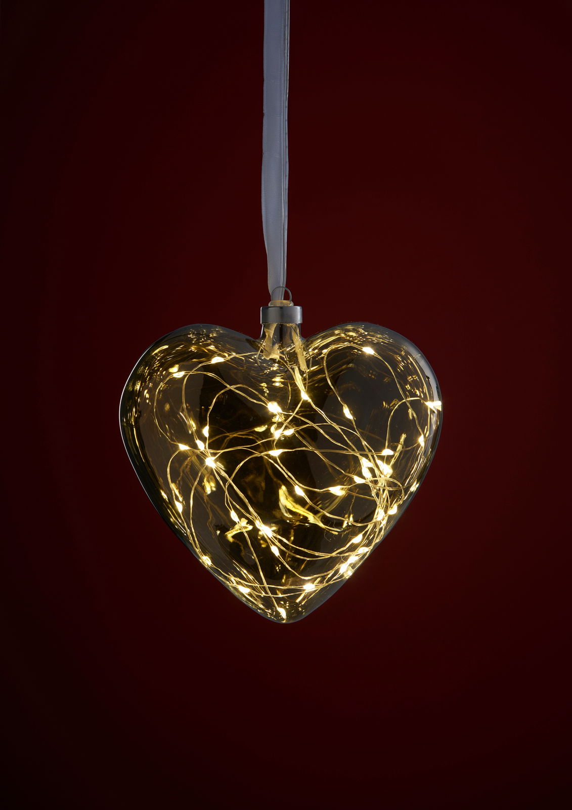 LED-Glasherz mit warmweißen Lichtern, hängend vor einem dunklen Hintergrund, frontal betrachtet.