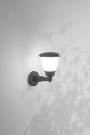 Außenwandleuchte mit klassischem Design, seitliche Perspektive, montiert an einer weißen Wand, beleuchtet mit weichem Licht.