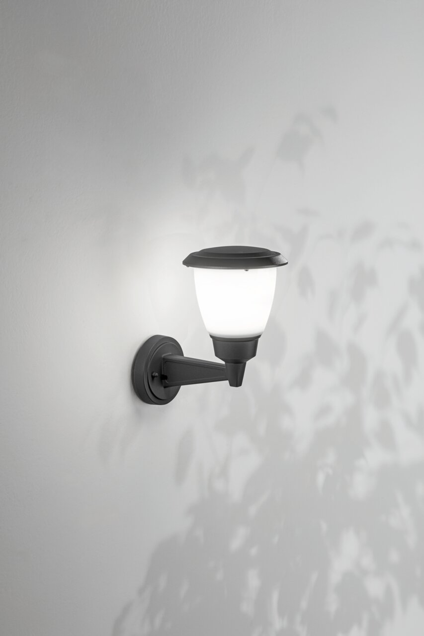 Außenwandleuchte mit klassischem Design, seitliche Perspektive, montiert an einer weißen Wand, beleuchtet mit weichem Licht.