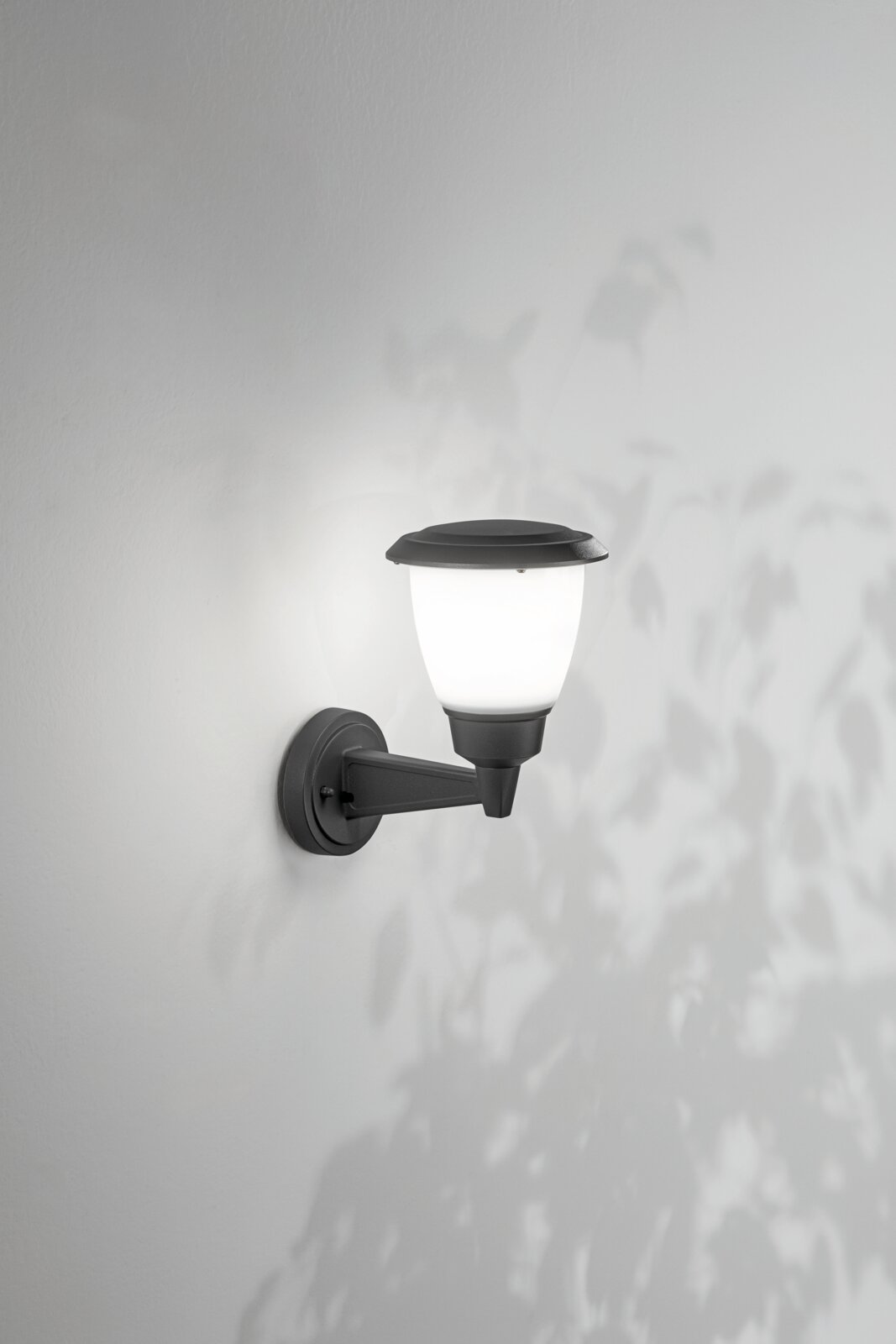 Buitenwandlamp met klassiek ontwerp, zijaanzicht, gemonteerd op een witte muur, verlicht met zacht licht.