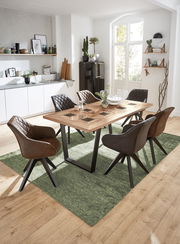 Esszimmer mit modernem Holztisch und sechs gepolsterten Stühlen in einer hellen, stilvollen Küche, Perspektive von schräg oben.