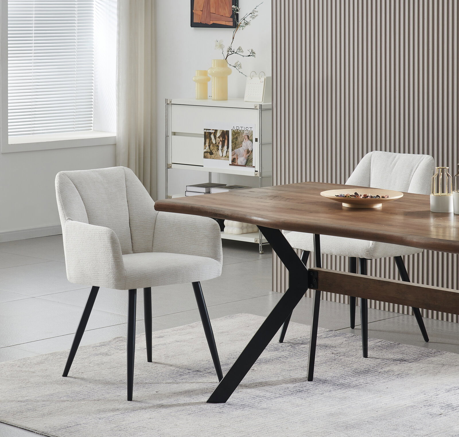 Modernes Esszimmer mit zwei hellgrau gepolsterten Stühlen mit schwarzen Beinen an einem Holzesstisch mit schwarzem Metallgestell, seitliche Perspektive im hellen Raum.