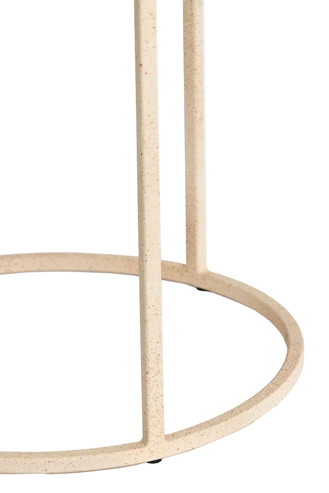 Nahaufnahme eines Beistelltischs mit runder, metallener Basis in cremefarbener Optik.