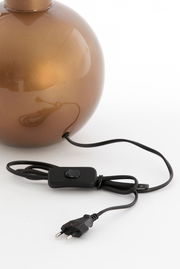 Nahaufnahme eines runden, bronzefarbenen Lampenfußes mit schwarzem Kabel und Schalter, seitliche Perspektive