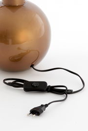 Nahaufnahme eines runden, bronzefarbenen Lampenfußes mit schwarzem Kabel und Schalter, seitliche Perspektive