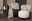 Zwei moderne Sessel mit stilvollen Zierkissen in einem eleganten Wohnzimmer-Setup, seitliche Perspektive.