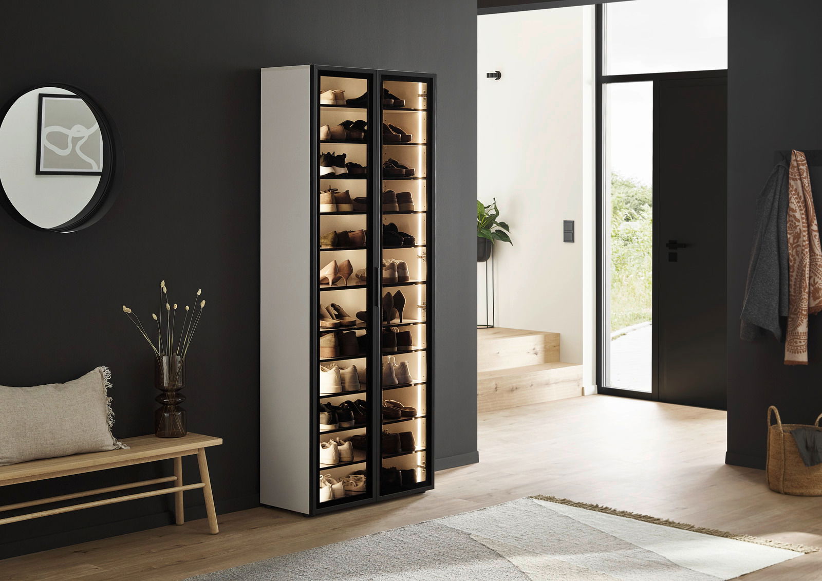 XL-Schuhschrank-Vitrine mit Glastüren, gefüllt mit Schuhen, in einem modernen Eingangsbereich, seitliche Perspektive