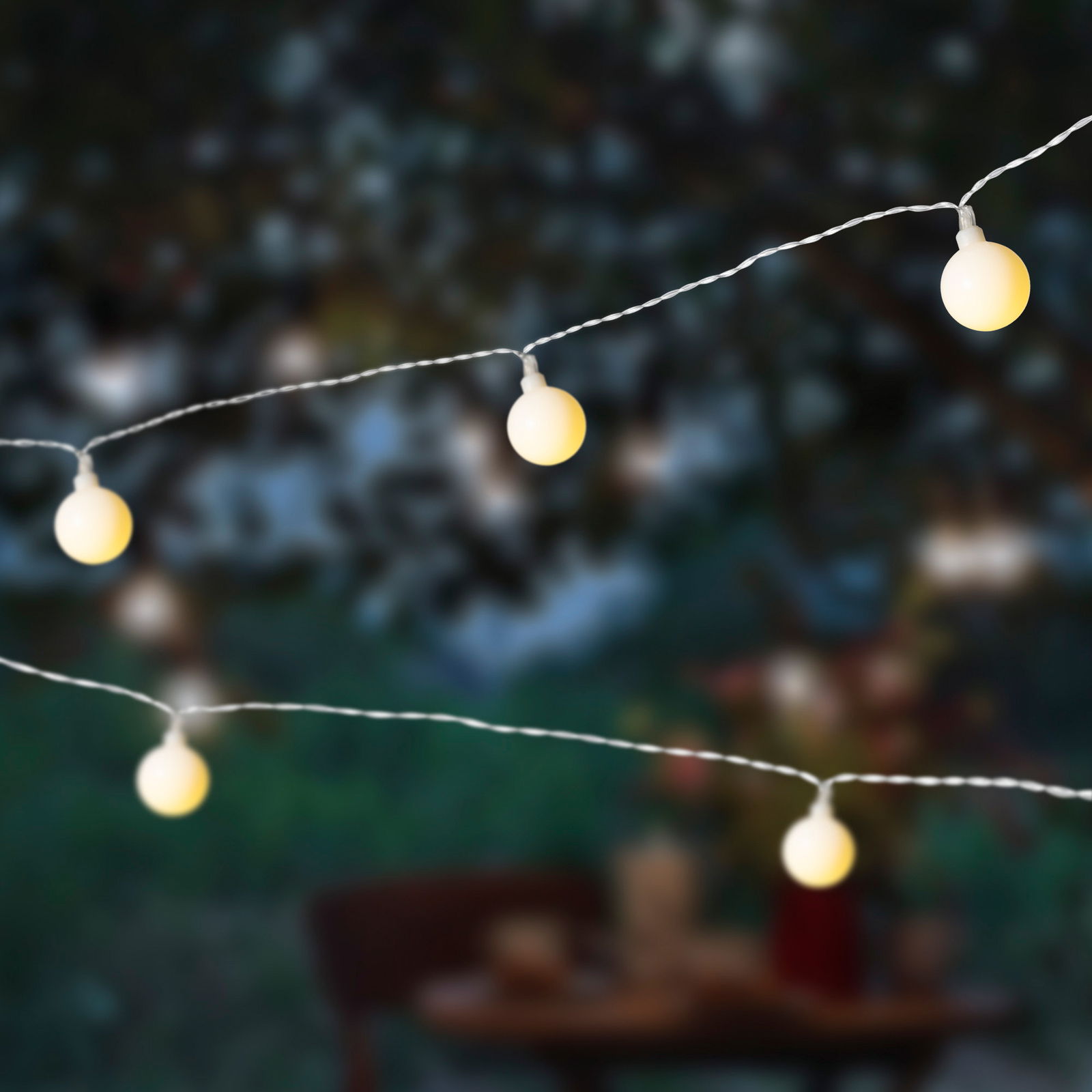 Lumineo Solar Cherrybeleuchtung Nahaufnahme von leuchtenden Solar-Lichterketten in Kirschform bei Dämmerung im Freien