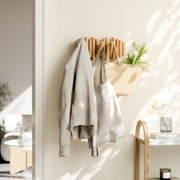 Houten wandkapstok met meerdere haken, waaraan een jas, een tas en een mand met bloemen hangen, zijaanzicht