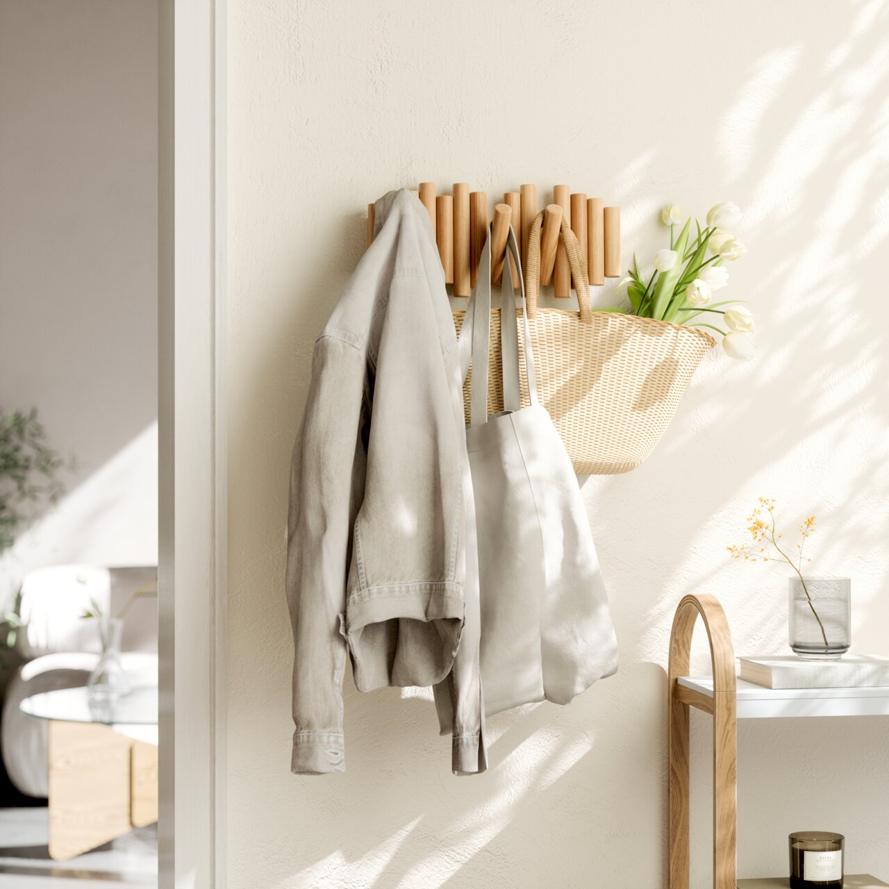 Wandgarderobe aus Holz mit mehreren Haken, an der eine Jacke, eine Tasche und ein Korb mit Blumen hängen, seitliche Perspektive