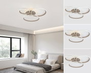 Moderne led-plafondlamp met drie in elkaar verweven ringen, gezien van onderaf, gemonteerd in een stijlvolle slaapkamer.
