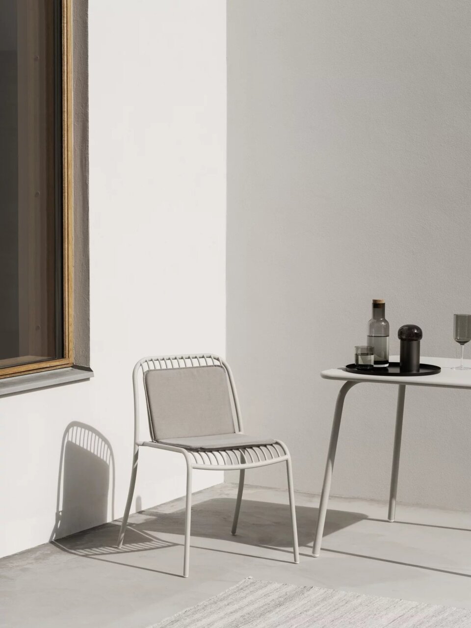 Ein modernes, minimalistisches Tablett in Schwarz auf einem Tisch im Freien, seitliche Perspektive.