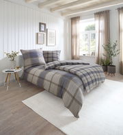 Gemütliches Schlafzimmer mit kariertem Bettwäsche-Set in Naturtönen, seitliche Perspektive