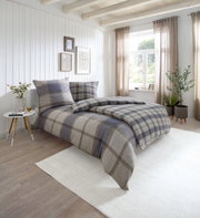 Gemütliches Schlafzimmer mit kariertem Bettwäsche-Set in Naturtönen, seitliche Perspektive
