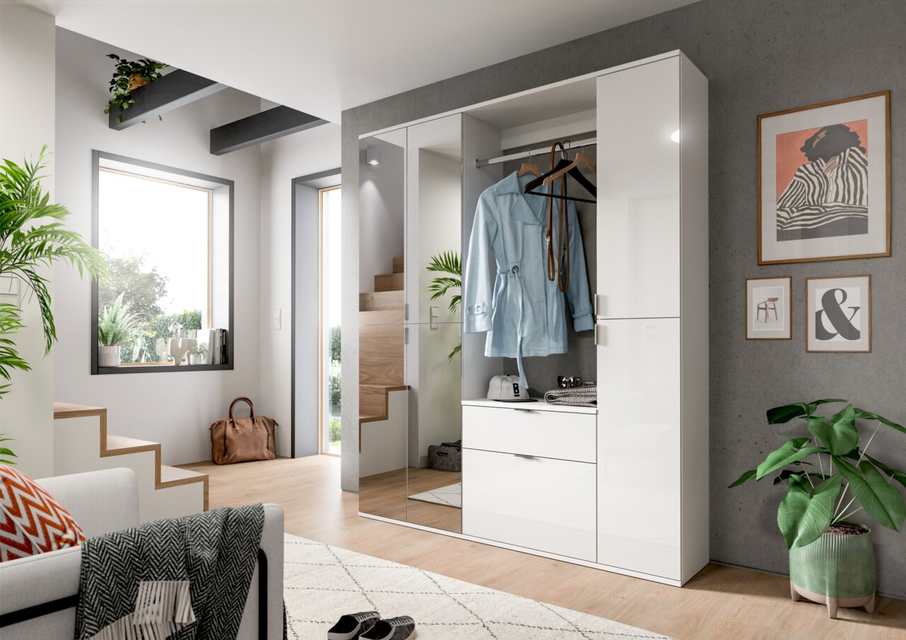 MID.YOU Garderobenkombination PROJEKT X Moderne weiße Kommode mit Hochglanzoberfläche, teilweise geöffnet, in einem stilvoll eingerichteten Raum mit Pflanzen und Wanddekorationen, aus frontaler Perspektive.