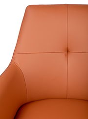 Nahaufnahme eines orangefarbenen Armlehnstuhls mit glatter Lederoberfläche, Ansicht von vorne.