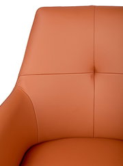 Nahaufnahme eines orangefarbenen Armlehnstuhls mit glatter Lederoberfläche, Ansicht von vorne.