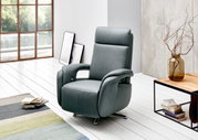 Moderner Relaxsessel in elegantem Grau, seitliche Perspektive, in einem hellen Raum mit großen Fenstern und stilvoller Dekoration.