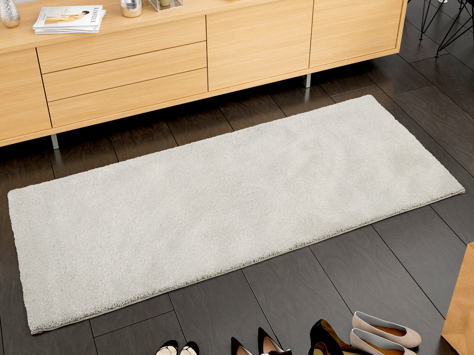 OCI Uni-Teppich NEW VILLA Rechteckiger, cremefarbener Uni-Teppich auf dunklem Holzboden, fotografiert aus der Vogelperspektive, vor einem hellen Holzschrank platziert.