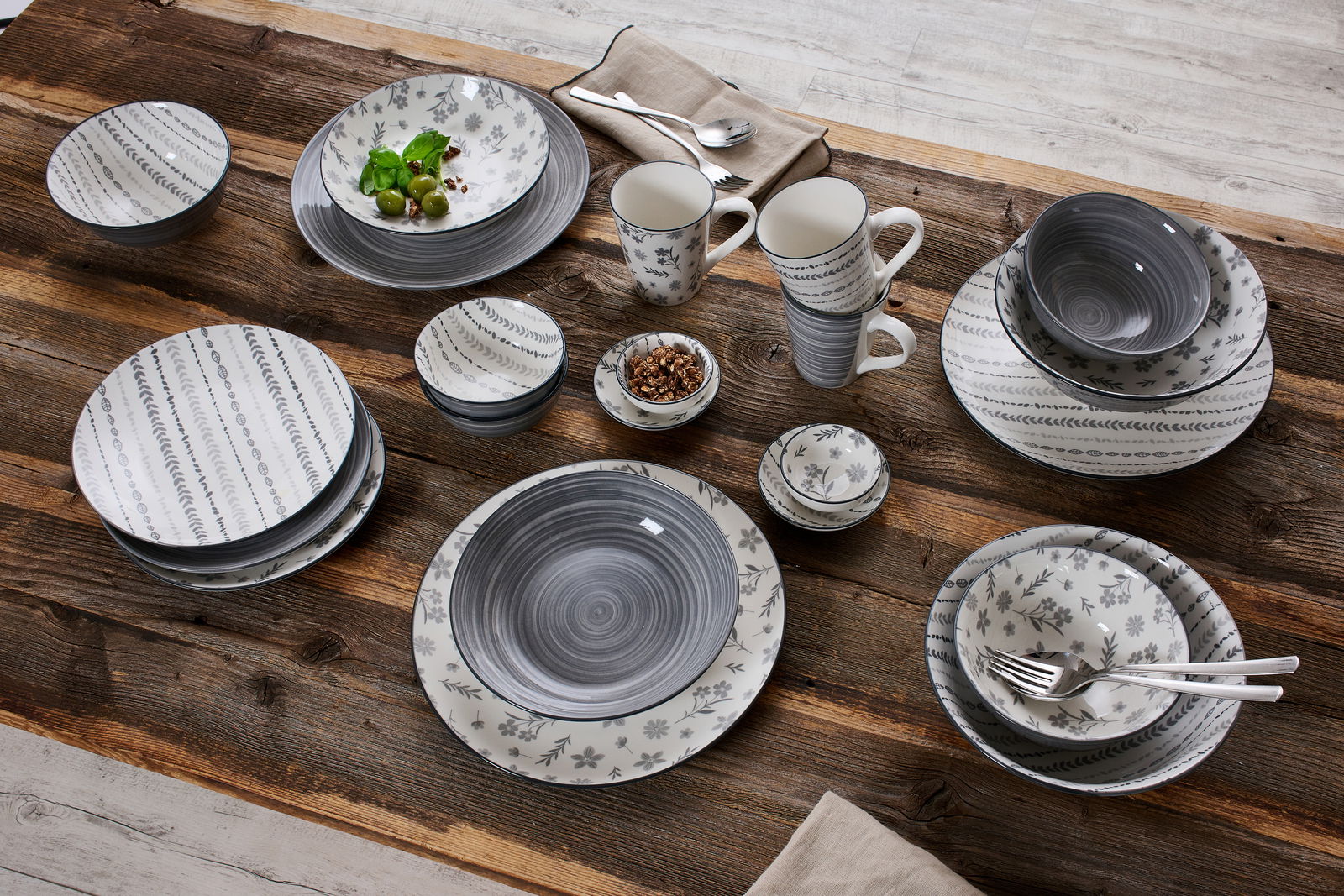 Ritzenhoff & Breker Kombiset 16-tlg. SENDAI Vogelperspektive auf ein 16-teiliges Kombiset 'Sendai' mit grauen und weißen Mustern auf einem Holztisch.