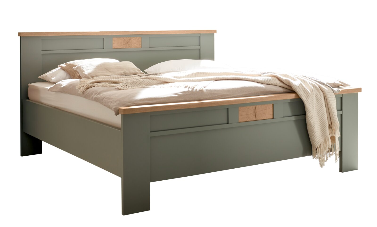 Modernes Doppelbett in Salbeigrün mit Holz-Akzenten an Kopf- und Fußteil, bezogen mit heller Bettwäsche und Decke, freigestellt auf weißem Hintergrund, Perspektive: schräg von vorne (3/4-Ansicht)