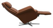 Seitliche Ansicht eines braunen Relaxsessels mit verstellbarer Rückenlehne und Fußstütze auf einem Metallfuß.