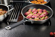 Bratpfanne Silence Pro 32cm mit Griff, gefüllt mit rosa Fleisch und Gemüse, auf einem Herd von schräg oben fotografiert.